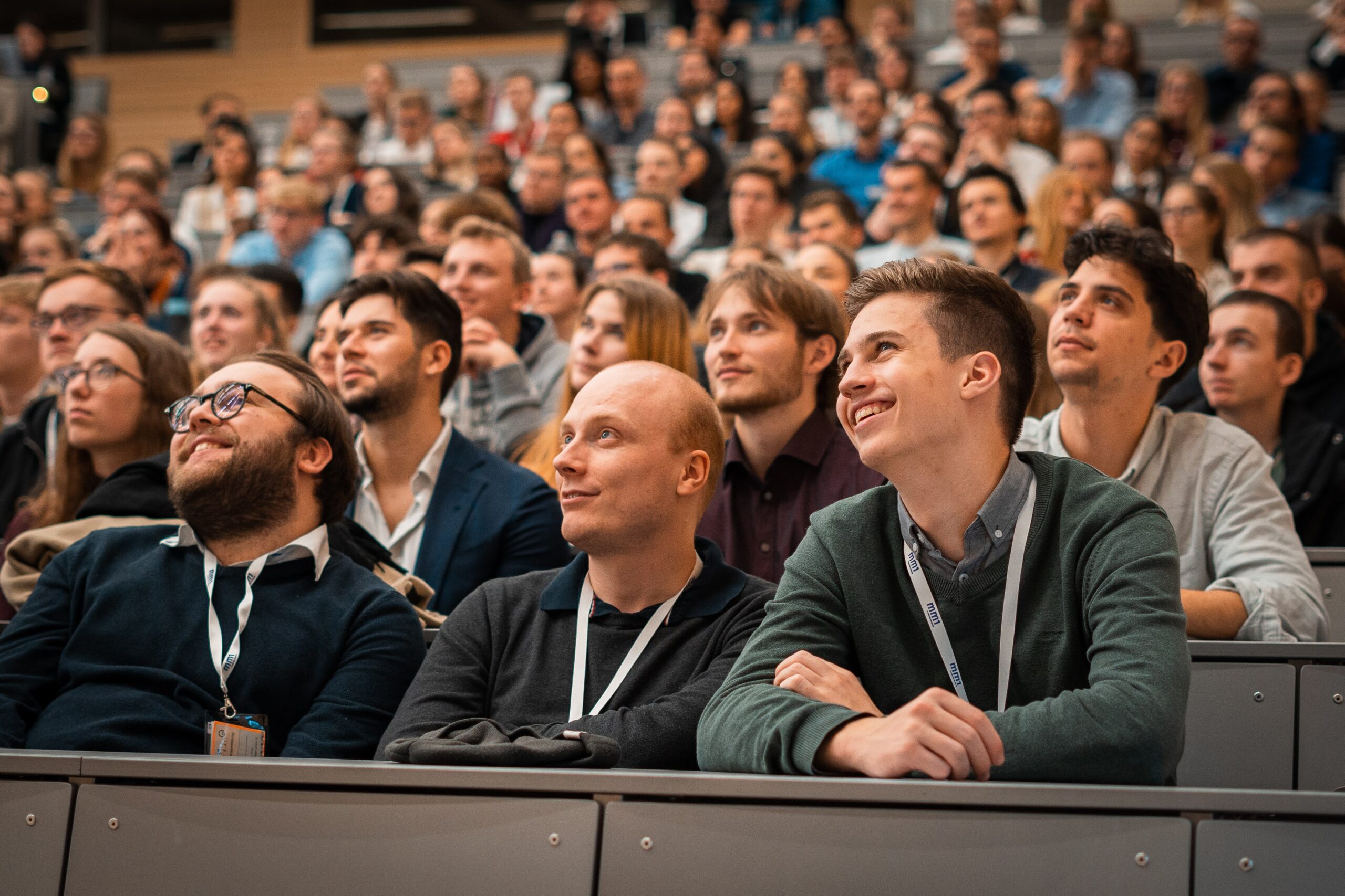 Im Fokus sind die Teilnehmenden des Events in Frankfurt am Main. sie schauen gespannt bis amĂźsiert nach links