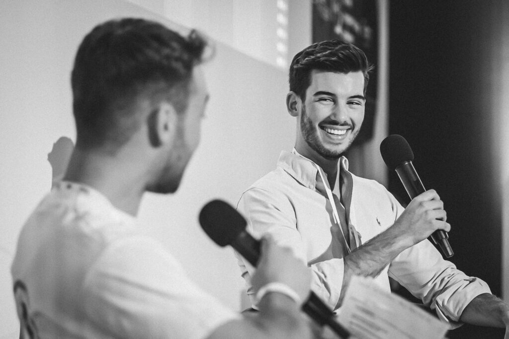 Man sieht eine Interview-Situation während Einers Events in Frankfurt am Main. Das Foto ist schwarz weiß. Der Event-Redner muss gerade lachen