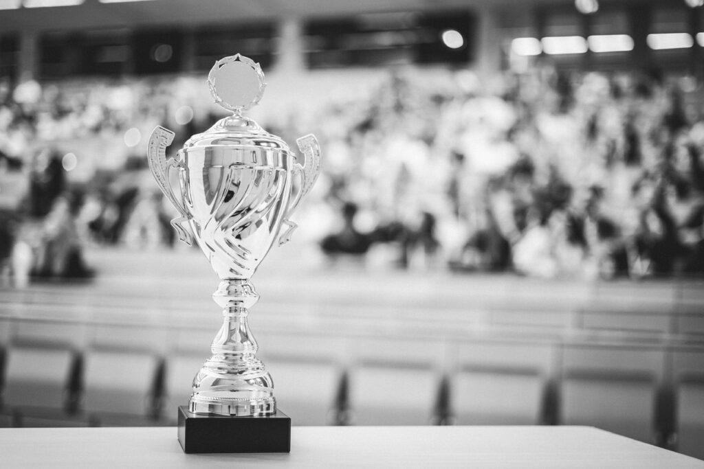 Trophäe steht im Vordergrund des Fotos, welches auf einem Event entstanden ist