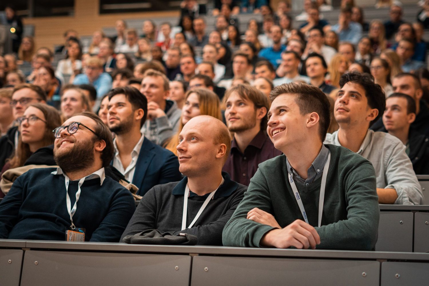 Im Fokus sind die Teilnehmenden des Events in Frankfurt am Main. sie schauen gespannt bis amĂźsiert nach links
